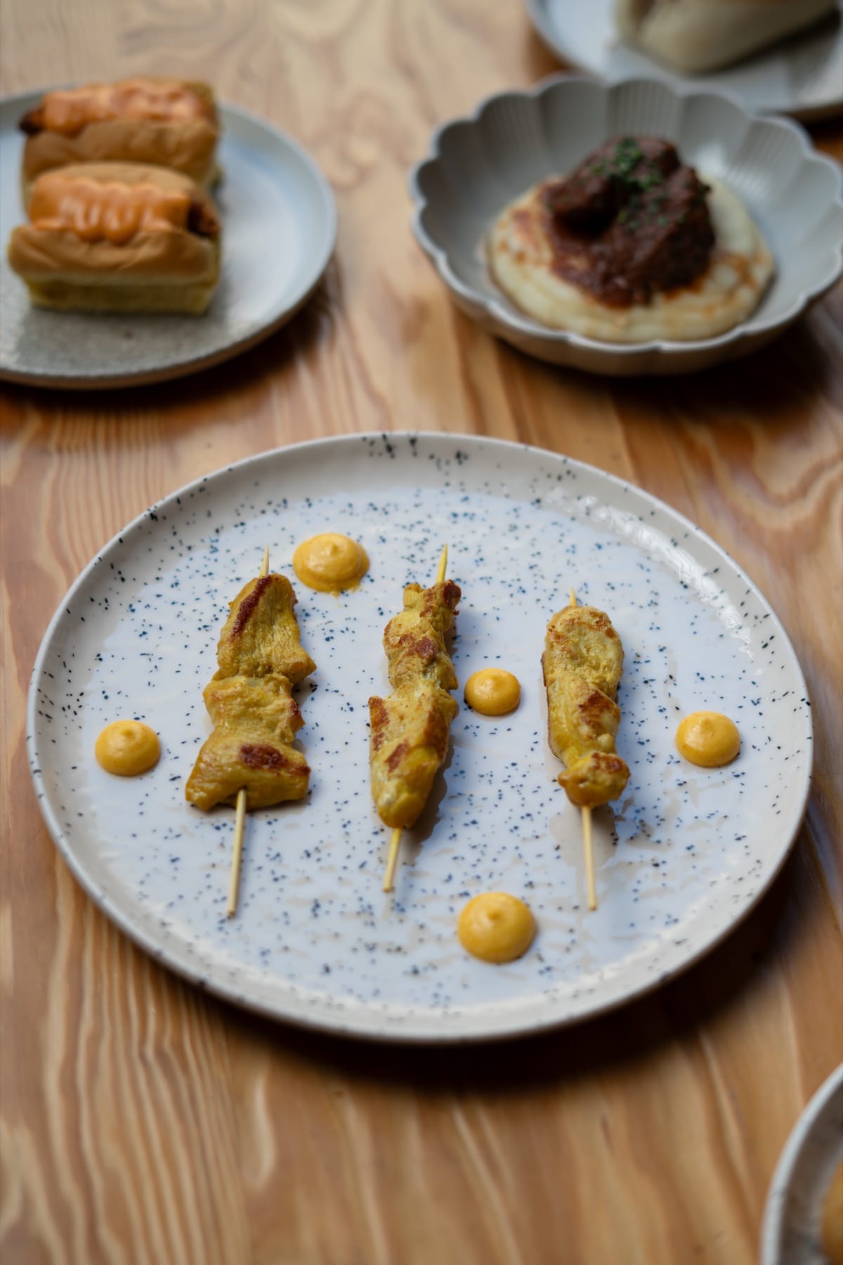 Fotografía de producto para redes: brochetas sobre plato de cerámica en mesa de madera